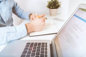 personne écrivant sur un cahier blanc