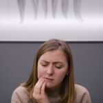 Une femme adulte inquiète et souffrant d'un mal de dents est assise dans un cabinet dentaire.